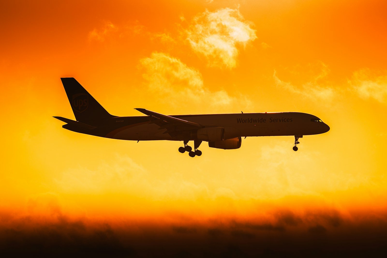 Cargo plane silhouetted against an orange sky