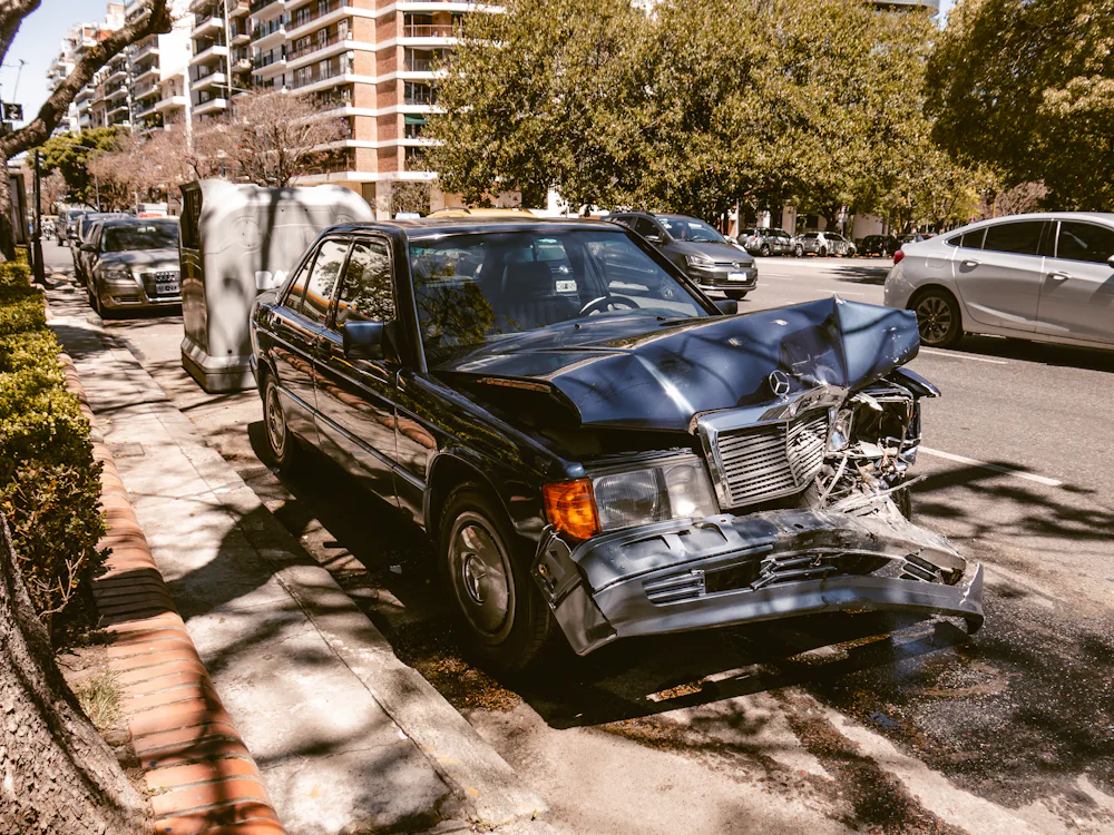 Une voiture noire accidentée, à l’avant enfoncé