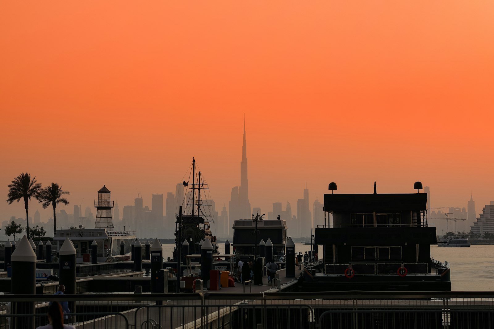 Dubai skyline silhouetted against an orange sky