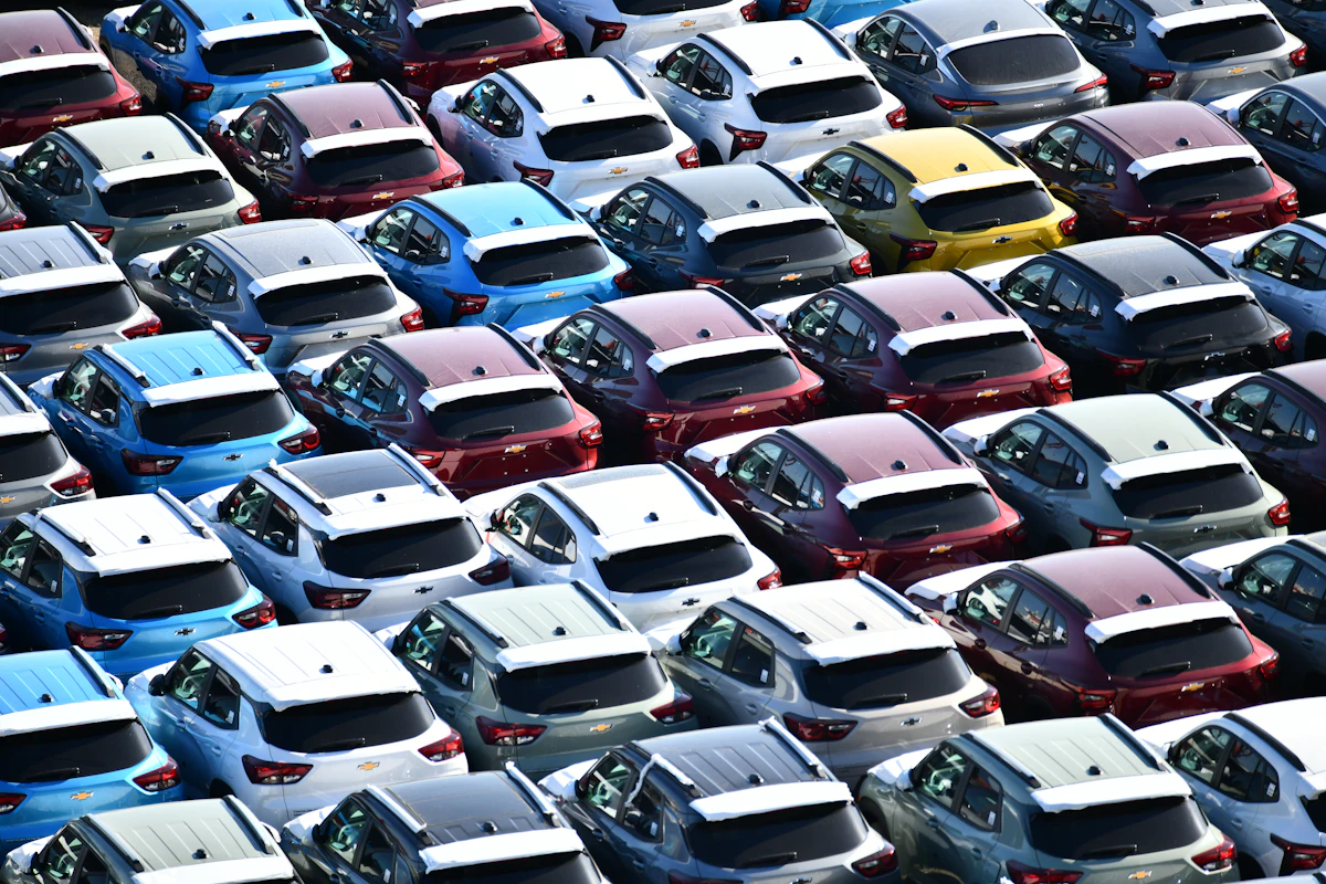 Rangées de voitures garées sur un grand parc automobile, vues d’en haut